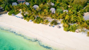 Kristal berrak suların beyaz kumlu kıyılarla buluştuğu ve rüzgarda hışırdayan palmiye ağaçlarının seslerinin rahatlatıcı bir kaçış sunduğu Zanzibar Sahili 'nin sakinliğini ve güzelliğini hissedin..