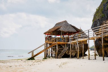 Zanzibar Adası nefes kesen çarpıcı bir tropik plaja ev sahipliği yapar. Beyaz kum, palmiye ağaçları ve kristal berraklığında turkuaz sular ılık bir yaz gününde yumuşacık bulutlarla mavi gökyüzüne karşı kusursuz bir şekilde harmanlanır., 