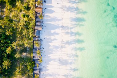 Kendinizi Zanzibar Adası 'nın tropikal plajının doğal güzelliğine bırakın. Beyaz kumları, sallanan palmiye ağaçları ve kristal berrak turkuaz sularıyla güneşli bir yaz gününde mavi gökyüzü ve tüylü bulutlar karşısında.. 