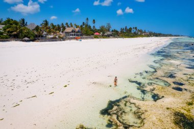 Beyaz kumlu, sallanan palmiye ağaçları ve berrak turkuaz sularıyla güneşli bir yaz gününde mavi gökyüzü ve kabarık bulutları olan tropikal bir cennete kaçmak. Zanzibar Adası en iyisi. 