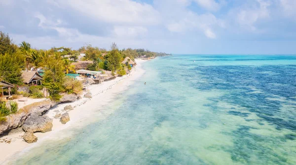 Zanzibar Adası nefes kesen çarpıcı bir tropik plaja ev sahipliği yapar. Beyaz kum, palmiye ağaçları ve kristal berraklığında turkuaz sular ılık bir yaz gününde yumuşacık bulutlarla mavi gökyüzüne karşı kusursuz bir şekilde harmanlanır., 