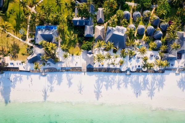 在阳光灿烂的夏日 桑给巴尔岛的热带海滩映衬着美丽的蓝天和蓬松的云彩 是一个值得一看的景象 白色的沙滩 棕榈树和清澈的碧绿海水结合在一起 形成了一个风景如画的背景 让人放松身心 — 图库照片