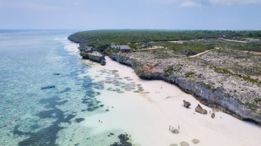 Zanzibar 'ın kumlu sahillerinin havadan görünüşü tropikal bir cennetin özünü yansıtıyor. Palmiye ağaçları, şemsiyeler, beyaz kumlar ve Hint Okyanusu' nun dingin mavi suları..