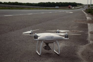 Quadcopter konsept fotoğrafını kapat. Gezici fotoğraf ve video için bir aygıt. Arka planda otoyol olan ön manzara fotoğrafçılığı. Duvar kağıdı, seyahat günlüğü, dergi, makale için yüksek kaliteli resim