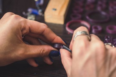 Yüzük balmumu oyma konsepti fotoğrafını kapat. El işçiliği. Metalle çalış. Arka planda enstrümanlar olan yan görüntü fotoğrafçılığı. Duvar kağıdı, seyahat günlüğü, dergi, makale için yüksek kaliteli resim