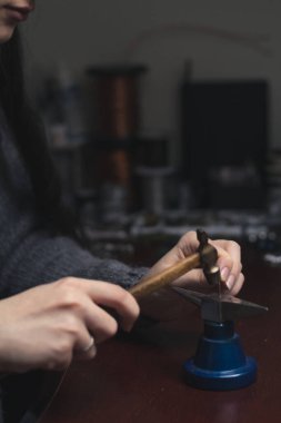 Kablo mücevher konsepti fotoğrafı çekiyoruz. İşteki kadın. Arka planda profesyonel aletler olan yan görüş fotoğrafçılığı. Duvar kağıdı, seyahat günlüğü, dergi, makale için yüksek kaliteli resim