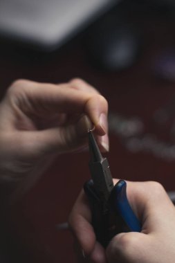 Mücevher konsepti fotoğrafı için uzun pense kapat. Bükme kablosu. Arka planda profesyonel aletler olan yan görüş fotoğrafçılığı. Duvar kağıdı, seyahat günlüğü, dergi, makale için yüksek kaliteli resim