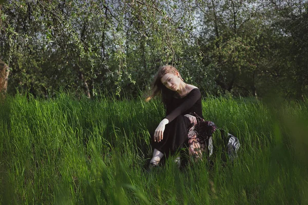女性を直接見つめ 背の高い草の風光明媚な写真に座っている 背景に自然の風景と写真 高品質の壁紙 旅行ブログ 記事のための写真のコンセプト — ストック写真