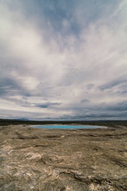 Patlamalar arasında harika bir gaysir manzarası fotoğrafı. Arka planda bulutlu gökyüzü olan güzel doğa manzara fotoğrafçılığı. Idyllic sahne. Duvar kağıdı, seyahat günlüğü, dergi, makale için yüksek kaliteli resim