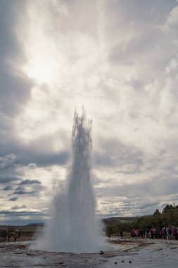 Termal gayzer püskürtme manzara fotoğrafı. Arka planda bulutlu gökyüzü olan güzel doğa manzara fotoğrafçılığı. Idyllic sahne. Duvar kağıdı, seyahat günlüğü, dergi, makale için yüksek kaliteli resim