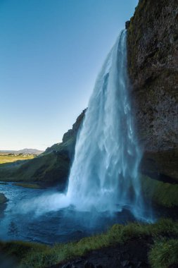 Seljalandsfoss şelalesi manzara resmi. Arka planda vadi olan güzel doğa manzarası fotoğrafçılığı. Idyllic sahne. Duvar kağıdı, seyahat günlüğü, dergi, makale için yüksek kaliteli resim