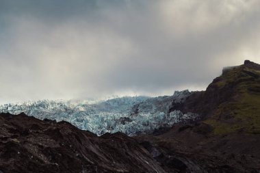 Buz manzaralı Rocky Dağı tepesi. Arka planda kasvetli gökyüzü olan güzel doğa fotoğrafçılığı. Idyllic sahne. Duvar kağıdı, seyahat günlüğü, dergi, makale için yüksek kaliteli resim