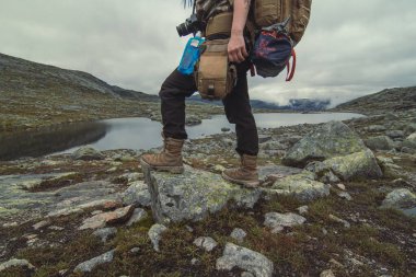 Dar nehir manzaralı fotoğrafçılığın yanındaki kayanın üzerinde duran yürüyüşçü. Arka planda dağları olan birinin resmi. Yüksek kalite duvar kağıdı. Reklamlar için fotoğraf konsepti, seyahat blogu, dergi, makale