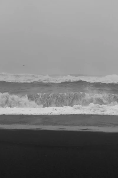 Rough ocean with foamy waves monochrome landscape photo. Beautiful nature scenery photography with sky on background. Idyllic scene. High quality picture for wallpaper, travel blog, magazine, article