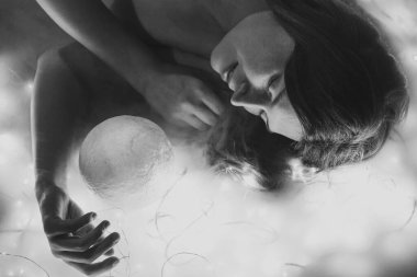 Sihirli kürenin tek renkli portresi olan güzel bayanı kapat. Peri ışıkları arkaplanlı yakın çekim yan görüntü fotoğrafçılığı. Reklamlar için yüksek kaliteli fotoğraf, seyahat blogu, dergi, makale