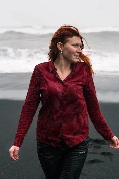 黒アイスランドのビーチの風光明媚な写真の魅力的な女性 背景に嵐の海を持つ人の写真 高品質の壁紙 旅行ブログ 記事のための写真のコンセプト — ストック写真