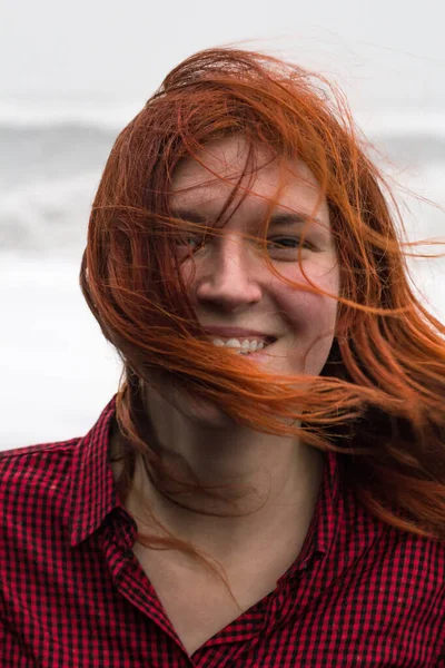 ビーチの肖像画の写真に乱雑な髪を持つ幸せな赤毛の女性を閉じます 背景がぼやけてフロントビューの写真を閉じます 旅行ブログ 記事のための高品質の写真 — ストック写真