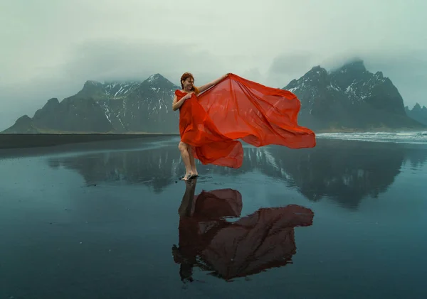 優雅な女性は赤いシフォンビーチの風光明媚な写真で包まれた 背景に山のある人の写真 高品質の壁紙 旅行ブログ 記事のための写真のコンセプト — ストック写真