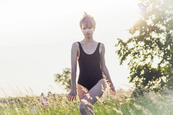 Woman in swimsuit walking across field scenic photography. Picture of person with sunshine on background. High quality wallpaper. Photo concept for ads, travel blog, magazine, article