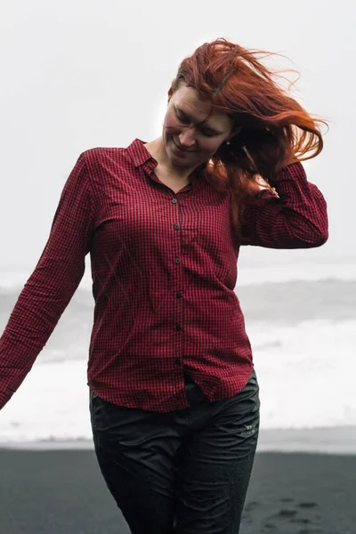 アイスランドのビーチの肖像画の写真にポーズを若い女性を閉じます 嵐の海を背景にフロントビューの写真を閉じます 旅行ブログ 記事のための高品質の写真 — ストック写真