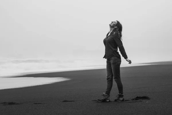 野生のレイニスフィヤラモノクロームの風景写真にインスピレーションを与える女性 背景に嵐の海を持つ人の写真 高品質の壁紙 旅行ブログ 記事のための写真のコンセプト — ストック写真