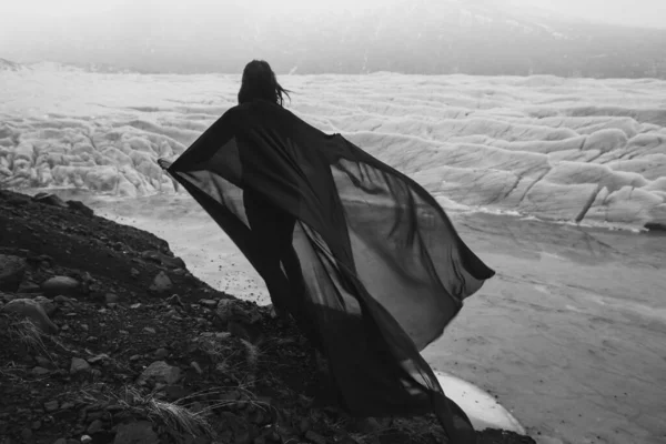 女性のロックモノクロームの風光明媚な写真にシフォン生地を振って保持 背景に氷河を持つ人の写真 高品質の壁紙 旅行ブログ 記事のための写真のコンセプト — ストック写真