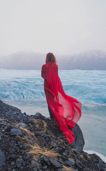 岩の風光明媚な写真に赤い布を持つエレガントな女性 背景に古代の氷山の人の写真 高品質の壁紙 旅行ブログ 記事のための写真のコンセプト — ストック写真