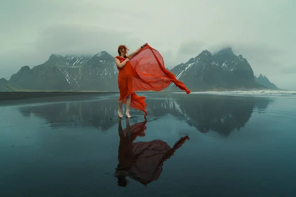 北部のビーチの風光明媚な写真に赤いドレスでグラマラスな女性 背景に山のある人の写真 高品質の壁紙 旅行ブログ 記事のための写真のコンセプト — ストック写真