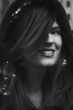 Close up smiling lady with fairy lights in hair monochrome portrait picture. Closeup front view photography with blurry background. High quality photo for ads, travel blog, magazine, article