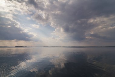 Clouds reflecting on water surface landscape photo. Beautiful nature scenery photography with skyline on background. Idyllic scene. High quality picture for wallpaper, travel blog, magazine, article