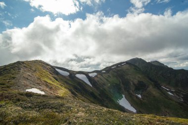 Ridge with remaining glaciers landscape photo. Beautiful nature scenery photography with clouds on background. Ambient light. High quality picture for wallpaper, travel blog, magazine, article