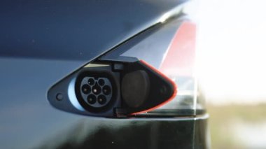 Tip 2 şarj ediliyor. EV 'yi şarj et, kapat. Elektrikli araç tip 2 'yi şarj ediyor. Çevre dostu alternatif enerji yeşil çevre kavramı. Elektrikli eko araba şarjı.