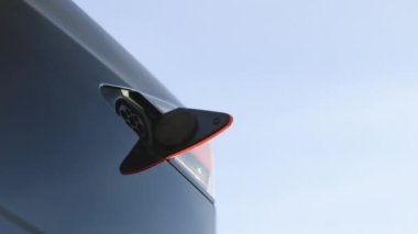 Elektrikli arabaya elektrik kablosu bağlayan tanınmayan bir adam. Elektrikli araç şarj ediliyor. Pili şarj ediliyor. Modern EV fişi takılı. Ekoloji alternatif enerjisini gelecek sürdürülebilir olarak kaydet.