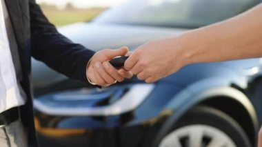 Satıcı araba fuarı ya da kuaför salonunun yeni sahibine anahtar veriyor. Erkek el araba galerisinde erkek eli için araba anahtarı verir. Tanınmayan bir otomobil satıcısı ve araba alan bir adam el sıkışıyor..