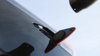 Bir pili şarj etmek için elektrikli araca bağlanan kabloyu şarj et. Elektrikli aracın 2. tip priz portu. Hızlı şarj eden soket tipi 2 elektrikli araba. Çevre dostu alternatif enerji