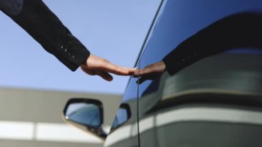 Elektrikli arabaya doğru yürüyen yakışıklı işadamlarına yakın çekim. Kapıyı açar ve içeri girer. İş adamı. Başarılı insanlarız. Lüks bir yaşam tarzı. Pozitif ruh hali. Zenginlik.