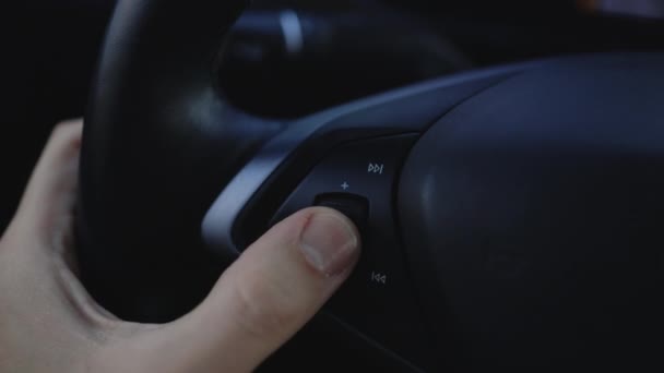 汽车控制音乐方向盘的特写视图 这只手在车里转动收音机的音量 关闭无线电音量 车里的音乐 现代音乐技术 — 图库视频影像