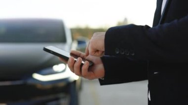 Tanınmayan iş adamı elektrikli arabanın uzaktan kumandası için akıllı telefon uygulaması kullanıyor, sürücü uzaktan yaklaşıyor, akıllı araba. Algılayıcı tarama yolu ileride araçlar için, tehlike, hız limitleri.