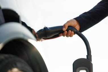 Bir pili şarj etmek için elektrikli araca bağlanan kabloyu şarj et. Elektrikli aracın 2. tip priz portu. Hızlı şarj eden soket tipi 2 elektrikli araba. Çevre dostu alternatif enerji