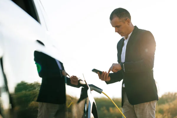 Muž Nabíjí Vozidlo Venku Slunečního Světla Podnikatel Odpojuje Elektromobil Nulovými — Stock fotografie