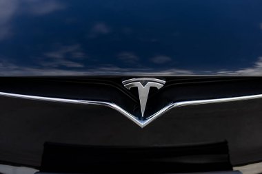 Lviv, Ukrayna - 17 Ekim 2022: Tesla Model X ekose logo rozetini kapatın. Siyah bir arabanın ön kaputunda Tesla logosu rozeti. TESLA logosu elektrikli arabanın yakın çekim görüntüsü.