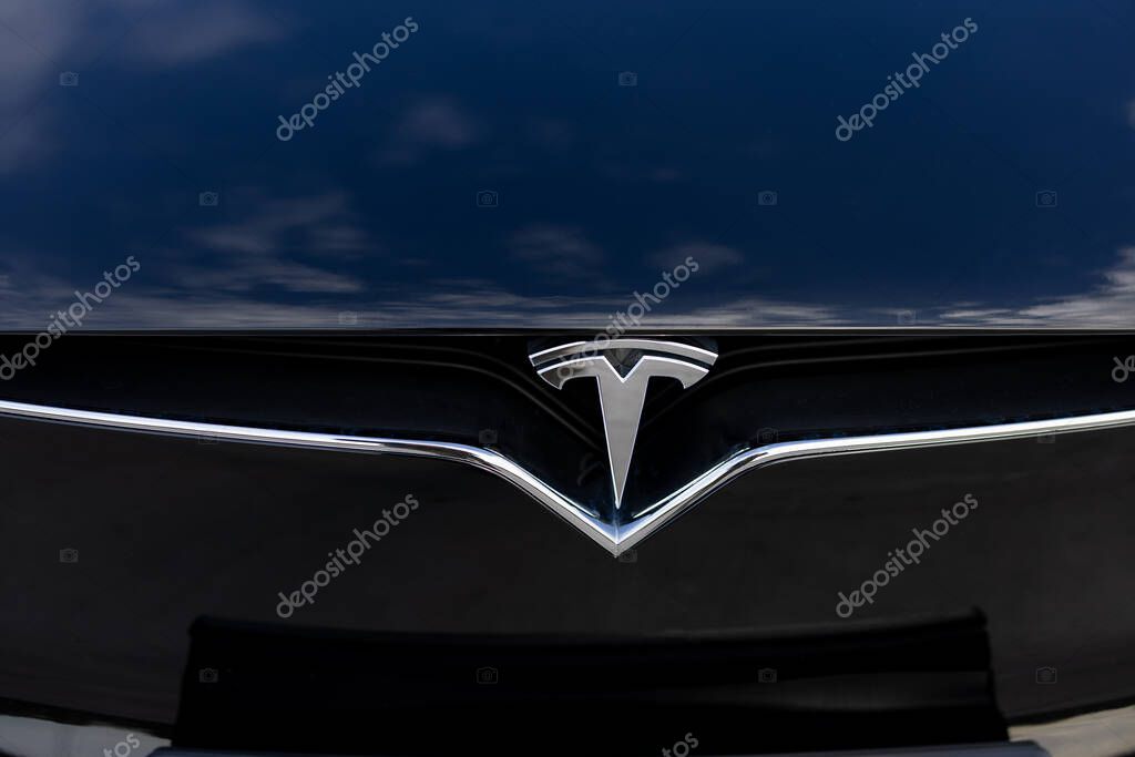 Lviv, Ukraine - October 17, 2022: Close up of Tesla Model X plaid logo badge. Tesla logo badge on a front hood of a black car. TESLA logo closeup shot on electric car.