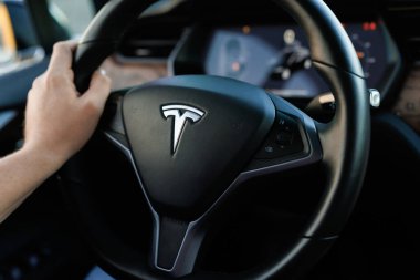 Lviv, Ukrayna - 17 Ekim 2022: Sokaklar boyunca Tesla arabasıyla gezen tanınmayan bir adam, ön monitörle Tesla 'nın aracını sürüyor. Otomatik pilot kullanan erkek sürücü..