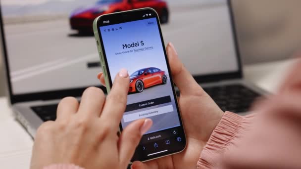 California 11月14 2022 テスラ車をオンラインで購入する意図で異なるモデルを閲覧するためのスマートフォンのショッピング テスラモデルYを注文 — ストック動画