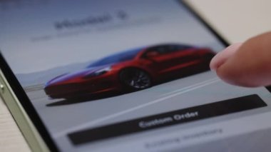 CALIFORNIA, ABD - 14 Kasım 2022: Satılık web sitelerindeki farklı tesla modellerine göz atan akıllı bir telefon ekranını kapatın. Tesla web sitesi, internetten bir tesla araba alıyor. Tesla SUV Y Modeli