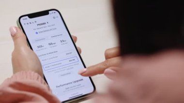 CALIFORNIA, ABD - 14 Kasım 2022: İnternet üzerinden bir Tesla araba almak için akıllı telefon alışverişi yapan kadınların ellerini kapatın. Tesla modeli Y performansı ve tam otomatik pilot siparişi veriliyor.