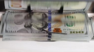 Close up of counting money in special machine. Currency financial banknote counter. USD dollars cash deposit machine. Paper money calculation. Finance concept