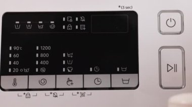 Çamaşır makinesi panelinin güç düğmesini kapat. Enerji sefaleti kavramını. Ev temizliği ve hijyen. Ev işleri.