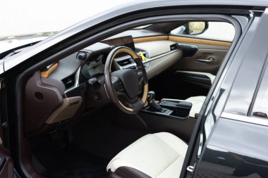 Araç içi lüks. Prestijli modern araba. Deri koltuklar, gösterge paneli ve direksiyon. Özel ahşap ve metal dekorasyonlu kokpit.
