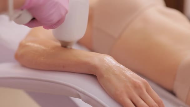 激光脱毛治疗 美容师手正在做激光脱毛手术 粉红手套握有消炎装置 医生的手用激光装置去除手上的毛 — 图库视频影像